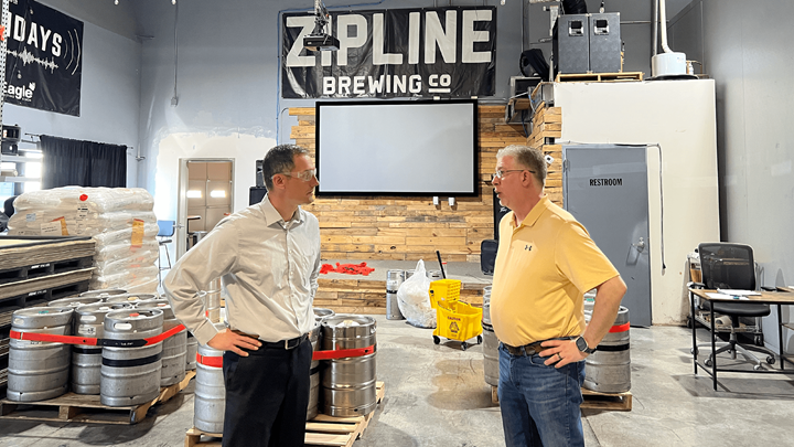 Two employees in a brewing company's workroom.