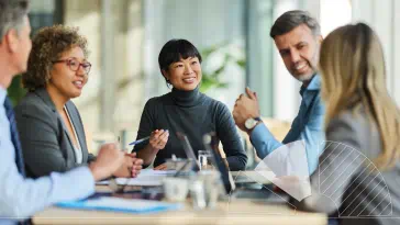 A group of people sitting around a table talking.