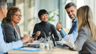 A group of people sitting around a table talking.