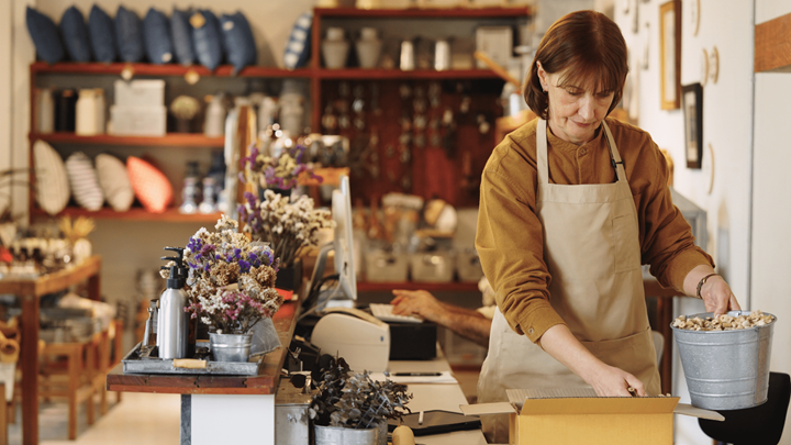 An employee filling a package in a storefront.