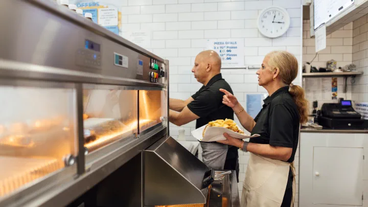 Two employees working at a deli